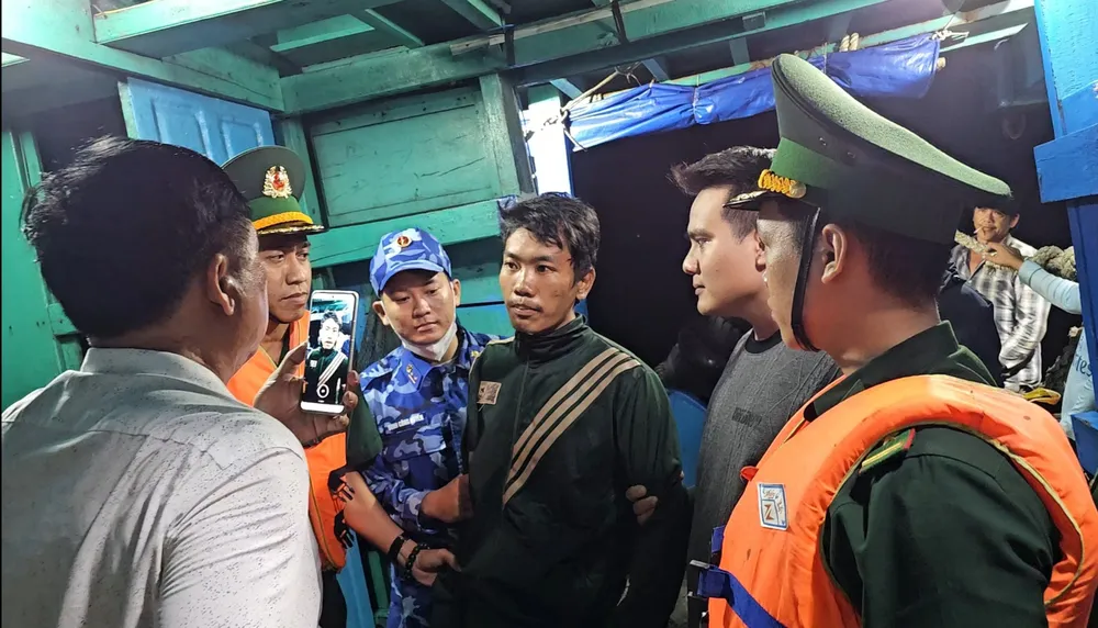Đối tượng trốn truy nã (giữa hình) bị các lực lượng phối hợp bắt giữ. Ảnh: QUANG DANH Bà Rịa- Vũng Tàu và TP.HCM phối hợp bắt đối tượng trốn truy nã bằng cách xin lên tàu cá làm việc