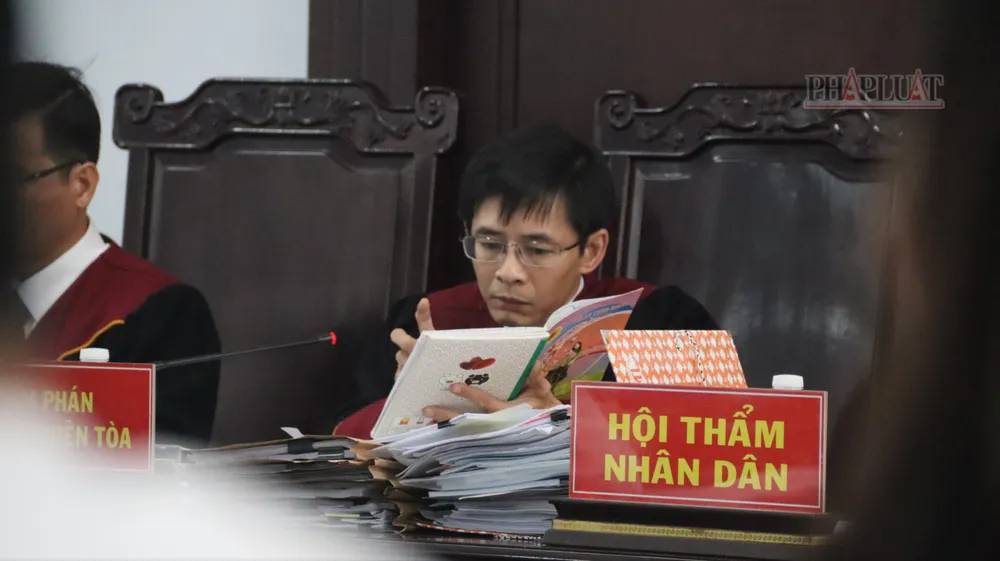 Chủ tọa công bố cuốn sổ ghi chép về việc nhận tiền của nhóm bị cáo là chủ xe. Ảnh: TRÙNG KHÁNH Thanh-tra-giao-thong.JPG