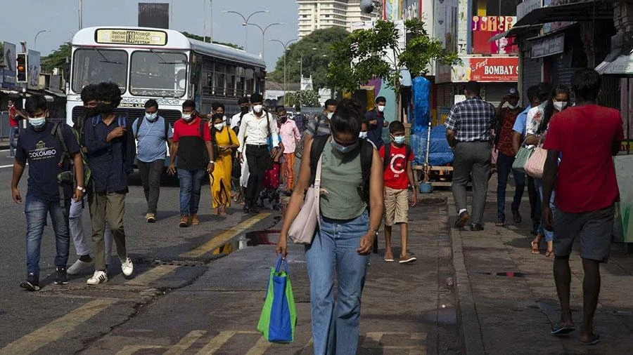 Người dân đi bộ trên đường phố thủ đô Colombo của Sri Lanka ngày 12-5. Ảnh: BLOOMBERG