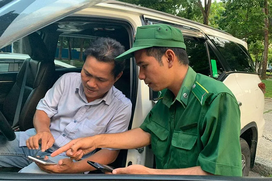 Nhân viên Công ty TNXP hướng dẫn chủ xe cài app để sử dụng dịch vụ thu phí đỗ ô tô dưới lòng được. Ảnh: ĐL