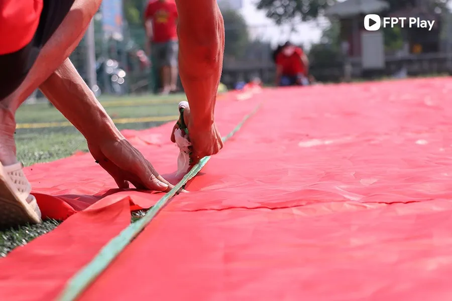 Việc may và ráp lá đại kỳ được thực hiện trên mặt sân bóng mới đủ để trải rộng hết 3.000 m2.