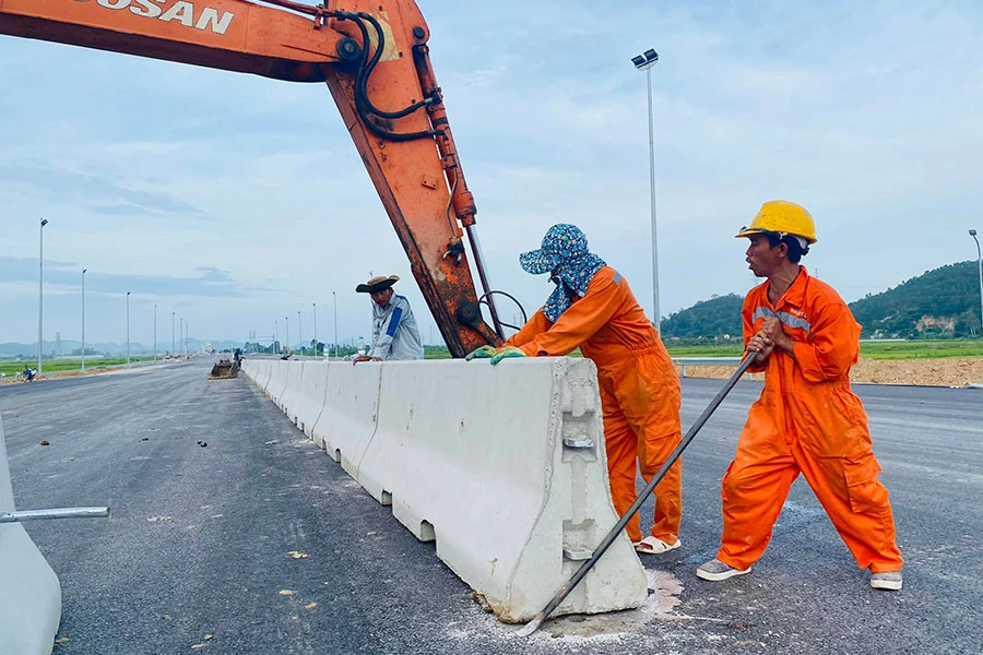 Các công nhân đang tiến hành lắp dải phân cách trên cao tốc Nghi Sơn - Diễn Châu. Ảnh: ĐẮC LAM Các công nhân đang tiến hành lắp dải phân cách trên cao tốc Nghi Sơn - Diễn Châu. Ảnh: ĐẮC LAM