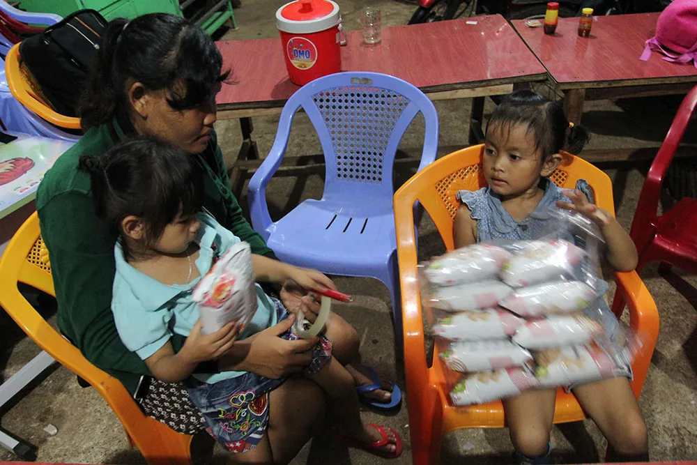 Hai bé Ngọc Yến và Lan Anh (bìa phải) cùng chia nhau đồ ăn. Ảnh: HOÀNG GIANG