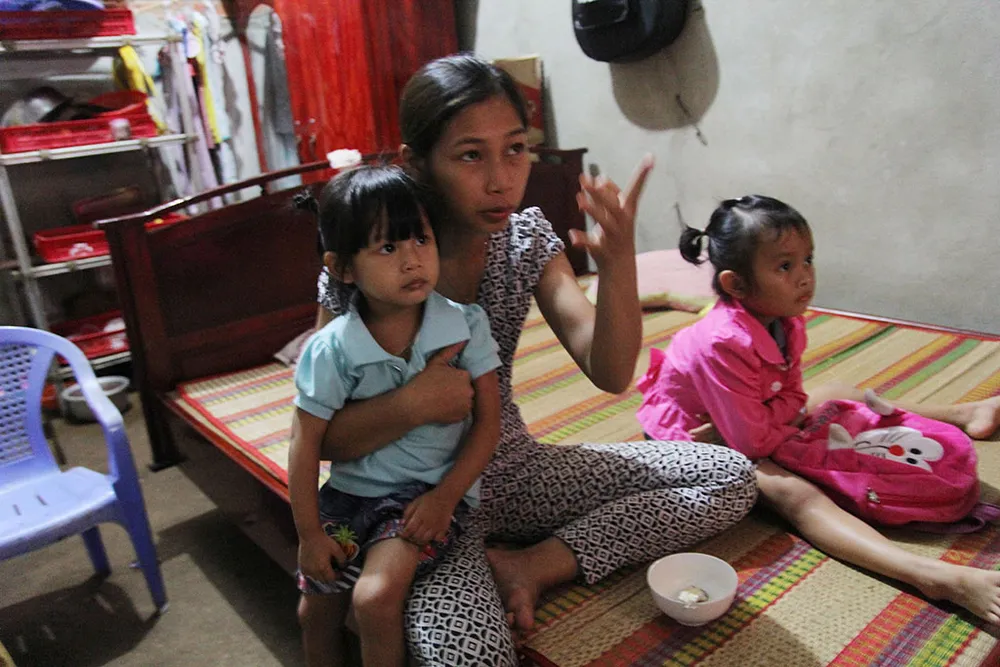 Chị Thu Trang cùng hai bé Ngọc Yến và Lan Anh (áo hồng) xem tivi trong nhà. Ảnh: HOÀNG GIANG