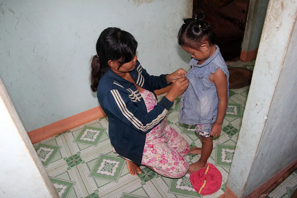 Bé Lan Anh được mẹ Thị Liền (xã Phước An, huyện Hớn Quản) thay đồ mới để về thăm cha mẹ nuôi. Ảnh: HOÀNG GIANG