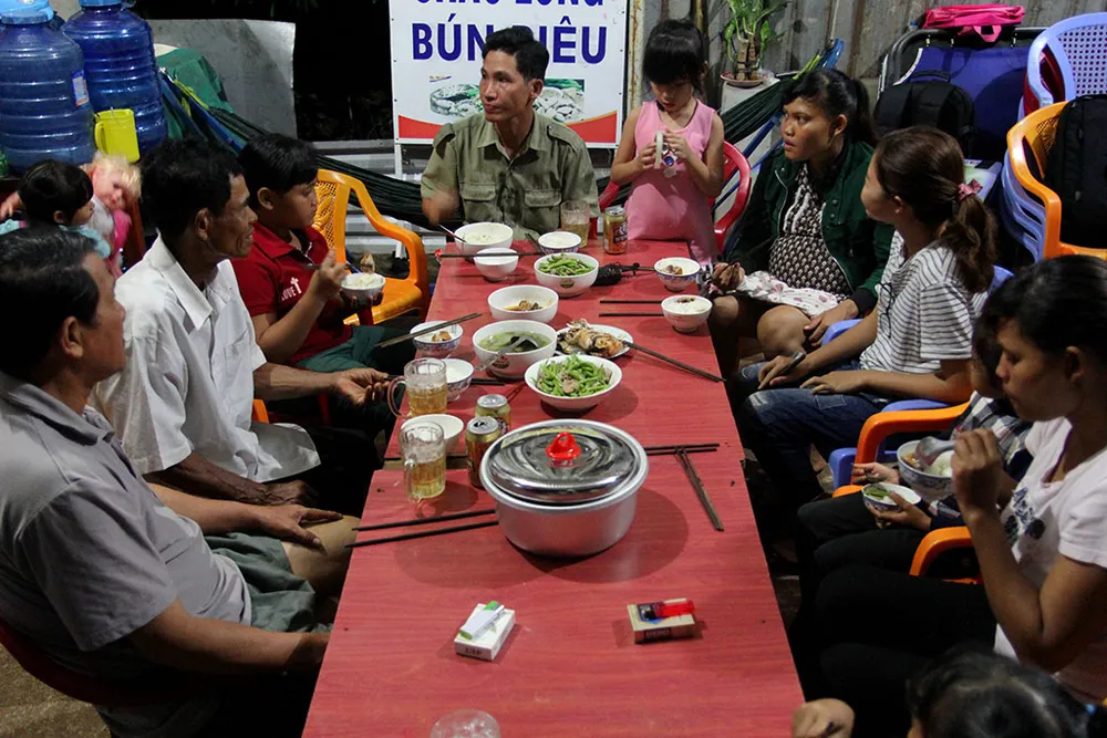 Bữa cơm thân tình của hai gia đình, họ vừa ăn vừa trò chuyện. Ảnh: HOÀNG GIANG