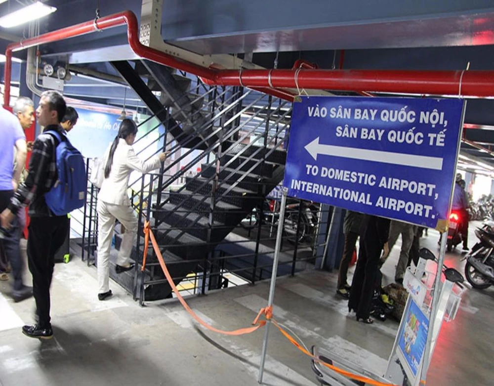 Cầu thang bộ lên các tầng trên của nhà xe và bảng hướng dẫn vào nhà ga quốc nội, sân bay quốc tế.