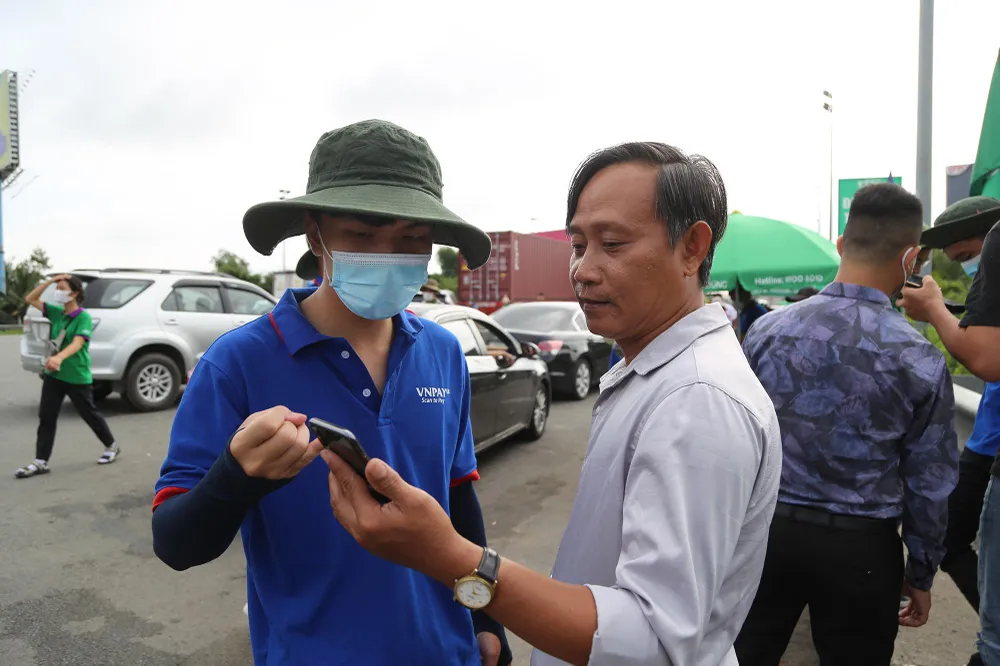 Chủ phương tiện nghe hướng dẫn phương thức nạp tiền vào tài khoản qua trạm thu phí. Đa số đều cho rằng việc dán thẻ ETC giúp họ lưu thông một cách nhanh chóng hơn.