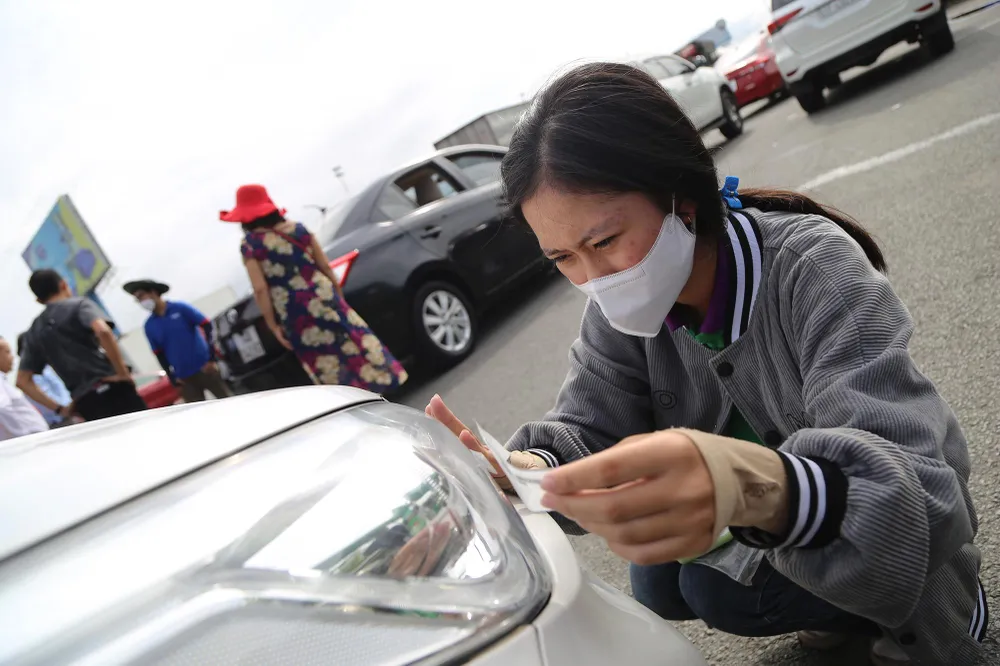 Nhân viên dán thẻ cho xe lưu thông qua trạm thu phí Long Phước sáng 1-8.