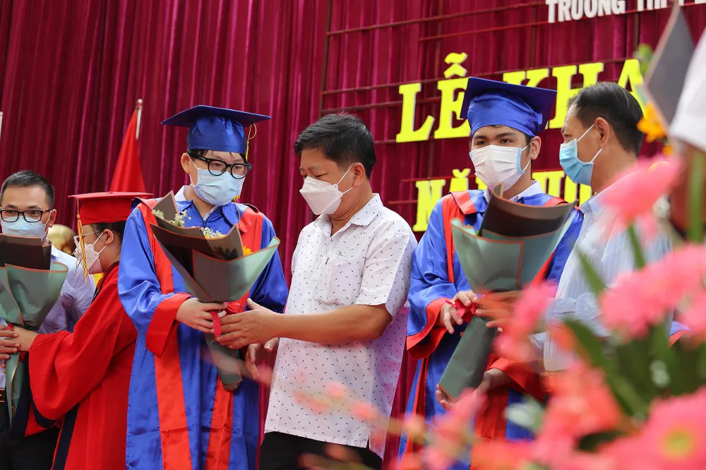 Nhóm học sinh lớp 10 có thành tích cao tặng hoa tri ân cha mẹ trong ngày khai giảng.