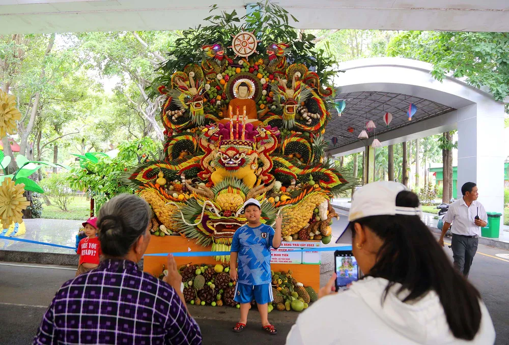 Em nhỏ thích thú chụp ảnh với tác phẩm đạt giải nhất cuộc thi.