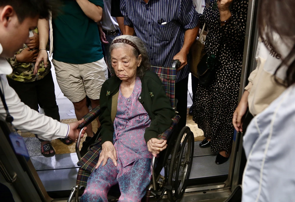 Một cụ già được nhân viên metro hỗ trợ lên tàu metro một cách chu đáo và an toàn. Ảnh: HOÀNG GIANG