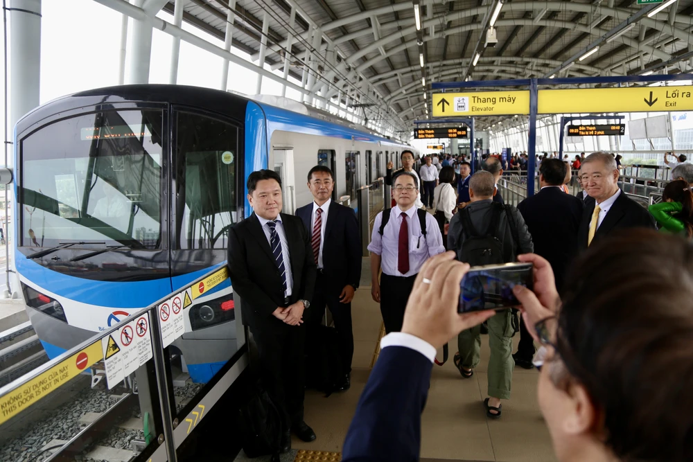Những người bạn Nhật Bản cùng nhau chụp ảnh lưu niệm với đoàn tàu metro vừa cập bến ga Suối Tiên. Ảnh: HOÀNG GIANG