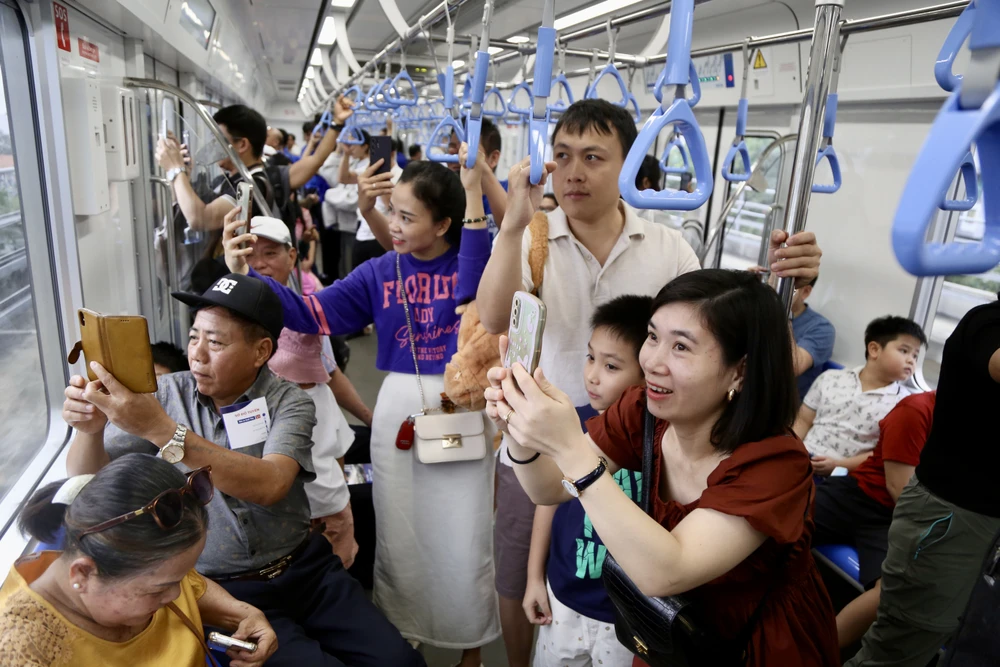 Người dân không giấu được sự háo hức khi tàu metro đi qua từng nhà ga. Ảnh: HOÀNG GIANG