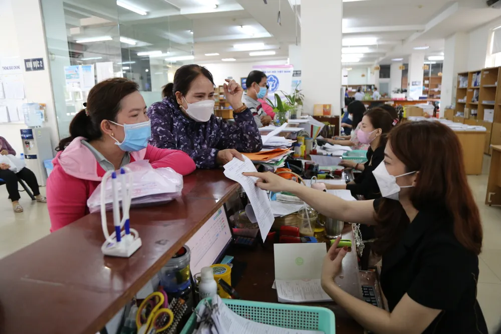 Cán bộ Bảo hiểm xã hội TP.HCM hỗ trợ người dân làm thủ tục. đội ngũ cán bộ (1).JPG