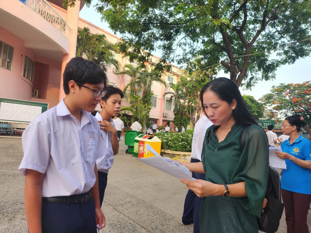 Trước cổng trường như thường lệ các giáo viên chủ nhiệm của trường có mặt từ rất sớm để điểm danh, nhắc nhở động viên học sinh của mình. thi vào lớp 10 6-6-1.jpg