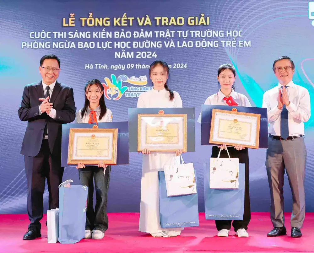 Ông Trần Văn Đạt, Vụ trưởng Vụ Giáo dục Chính trị và Công tác học sinh sinh viên (ngoài cùng bên trái) và ông Nguyễn Xuân Dũng, Chủ tịch HĐQT Công ty BITEX (ngoài cùng bên phải) cùng trao quà và bằng khen cho các em thí sinh xuất sắc đạt giải nhất ở các cấp Tiểu học, THCS và THPT. sang-kien-bao-dam-trat-tu-truong-hoc-1-825.jpg