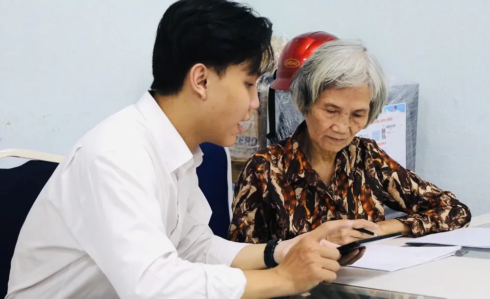 Bà Phùng Thị Bích Phương chăm chú học dùng điện thoại. Ảnh: MINH THƯ H1.JPG