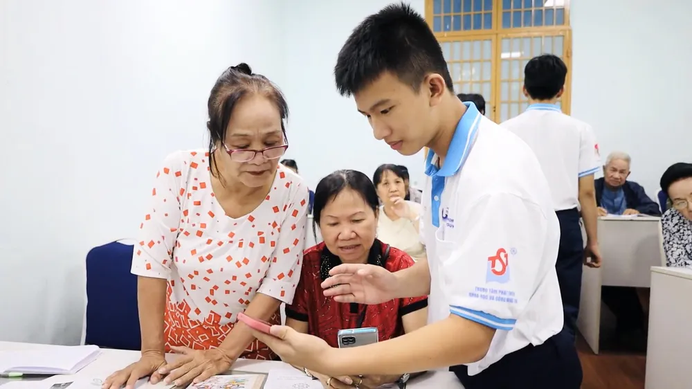 Tấn Dũng hăng say hướng dẫn cho các cô chú cách sử dụng ứng dụng Zalo. Ảnh: MINH THƯ H3.JPG