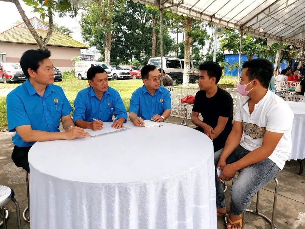Ông Phạm Văn Hiền (ở giữa), Phó giám đốc Trung tâm Tư vấn pháp luật LĐLĐ TP.HCM và ông Trần Văn Triều (thứ 2 từ trái qua), nguyên Giám đốc Trung tâm Tư vấn pháp luật LĐLĐ TP.HCM cùng hỗ trợ tư vấn cho NLĐ. Trung tâm Tư vấn pháp luật LĐLĐ