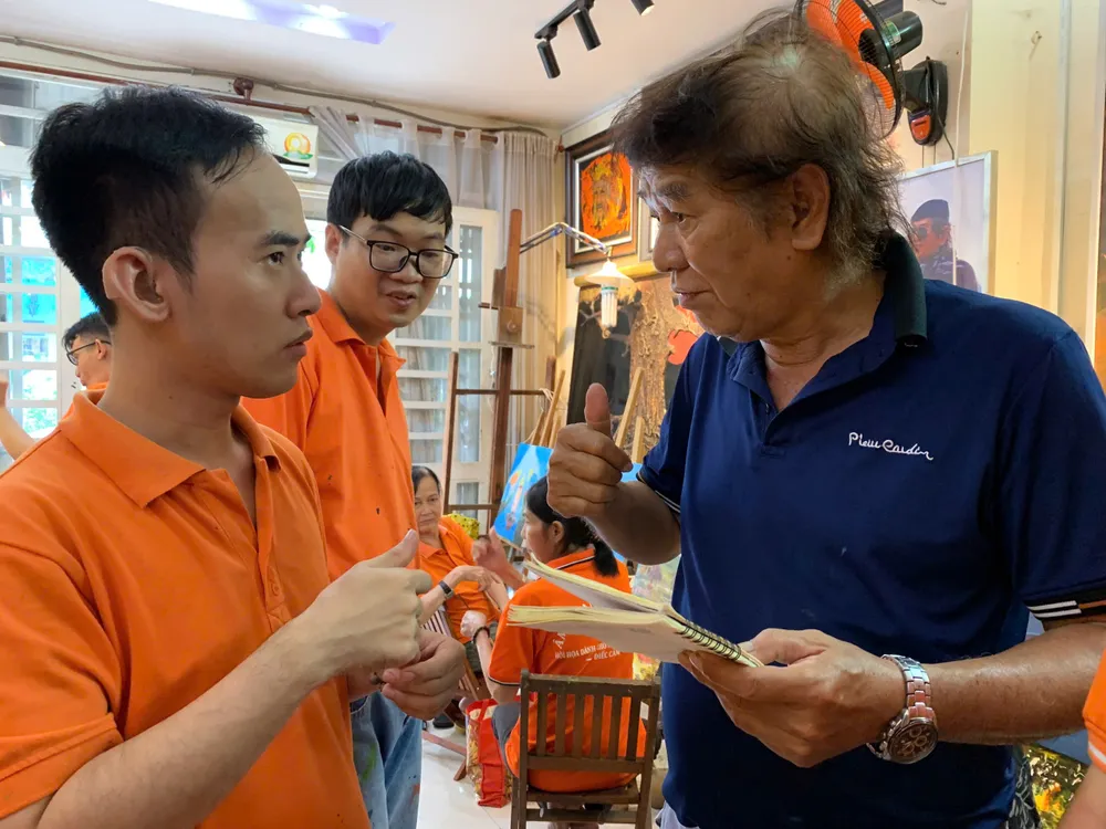 Nguyễn Ngọc Quý (ngụ Tân Bình) đã trải qua một hành trình đầy thách thức vì mất khả năng nghe, nói. Dẫu vậy, Quý không để những trở ngại này ngăn cản mình mà vẫn theo đuổi đam mê nghệ thuật. Trong ảnh: Thầy Y đang cố gắng miêu tả, trao đổi với học trò Nguyễn Ngọc Quý. N2.jpeg