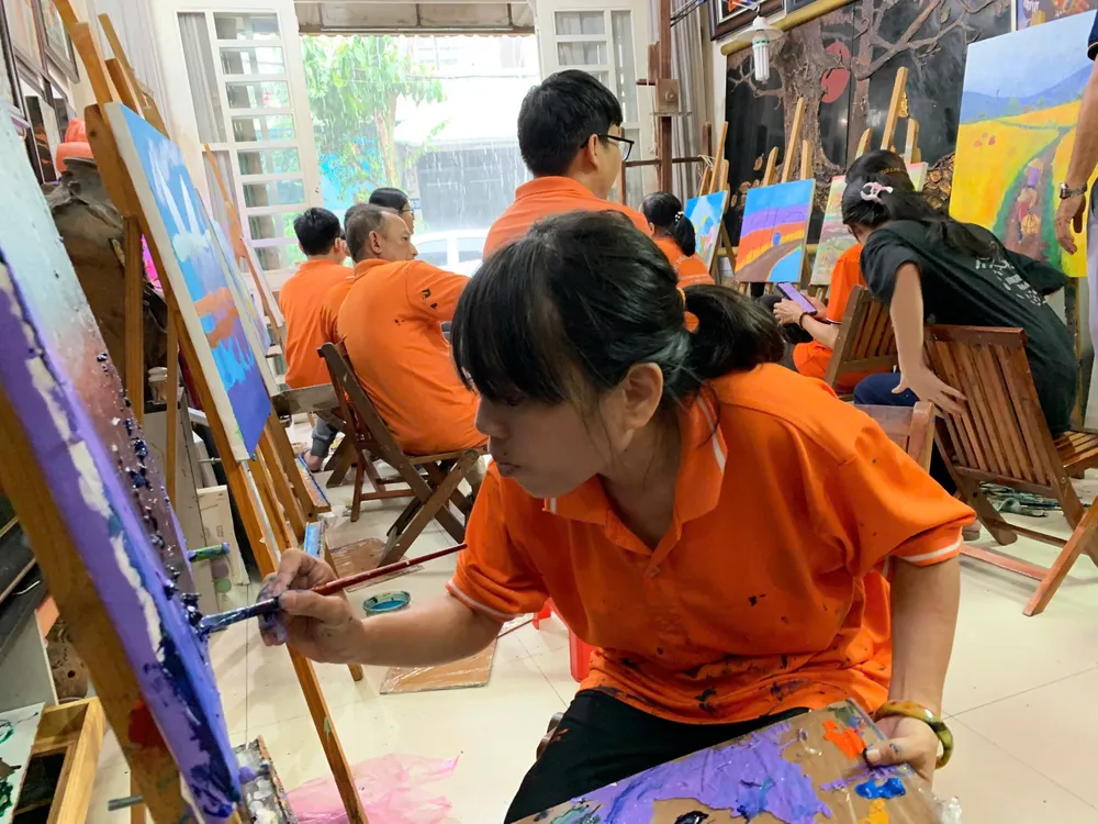 Chị Đinh Bảo Trân, học trò của thầy Y, chăm chú vẽ để hoàn thiện tác phẩm của mình. Lớp học vẽ miễn phí của thầy Y