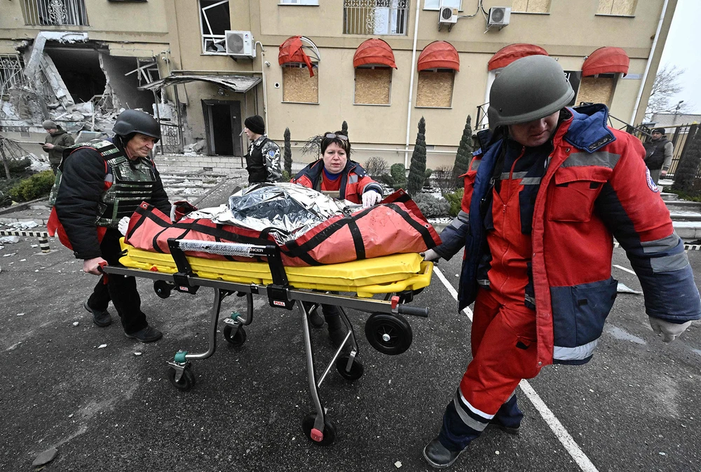 Nhân viên y tế đưa thi thể của một cư dân thiệt mạng sau cuộc pháo kích ở Kherson ra khỏi đống đổ nát. Ảnh: AFP/GETTY IMAGES