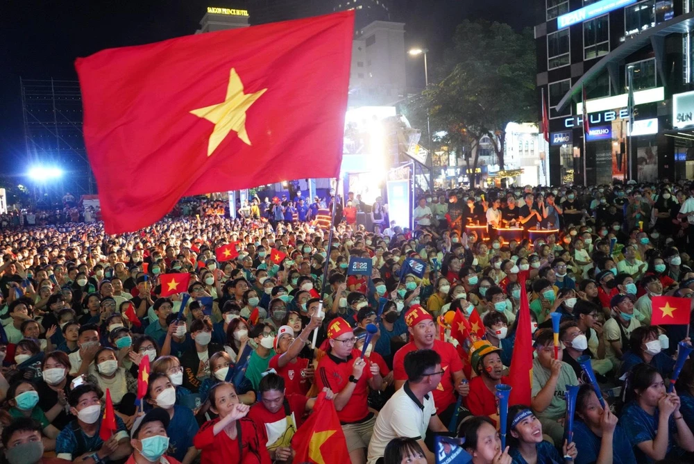 Cờ đỏ sao vàng rực rỡ giữa phố đi bộ Nguyễn Huệ. Sau 90 phút thi đấu hai đội U23 Việt Nam và U23 Malaysia vẫn giữ nguyên kết quả 0 - 0. Ảnh: TÂM THƠ