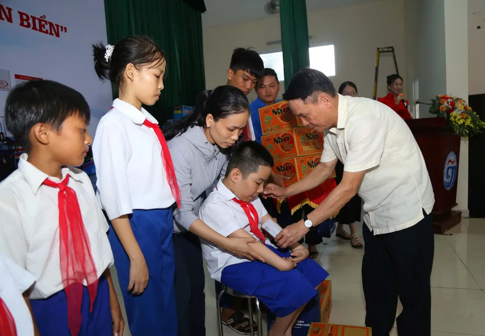 Em Nguyễn Văn Minh Trí, học sinh lớp 6C Trường Tiểu học - THCS Gio Việt, huyện Gio Linh được các bạn đoàn viên thanh niên bế lên sân khấu do em không thể di chuyển. Từ khi lọt lòng mẹ, Trí đã bị dị tật tứ chi, không thể tự lo sinh hoạt cá nhân. Bằng nỗ lực chăm lo của mẹ và ý chí mạnh mẽ, Trí đã rèn được cách viết bằng hai chân. Ba năm liền đạt danh hiệu học sinh giỏi, Trí chia sẻ lớn lên muốn trở thành bác sĩ để chữa bệnh cho mọi người. Ảnh: HOÀNG GIANG
