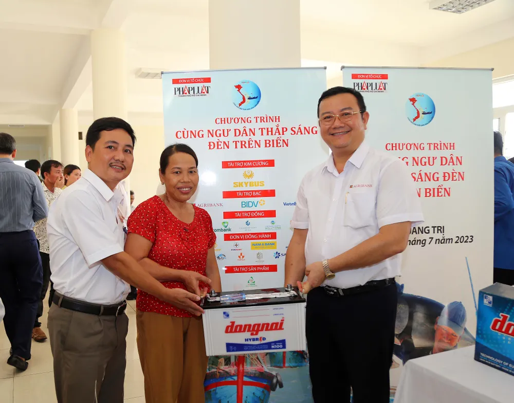 Ông Nguyễn Tiến Trường (phải), Phó Văn phòng Đại diện Agribank Khu vực Miền Trung, đại diện tặng quà cho ngư dân Quảng Trị. Ảnh: HOÀNG GIANG