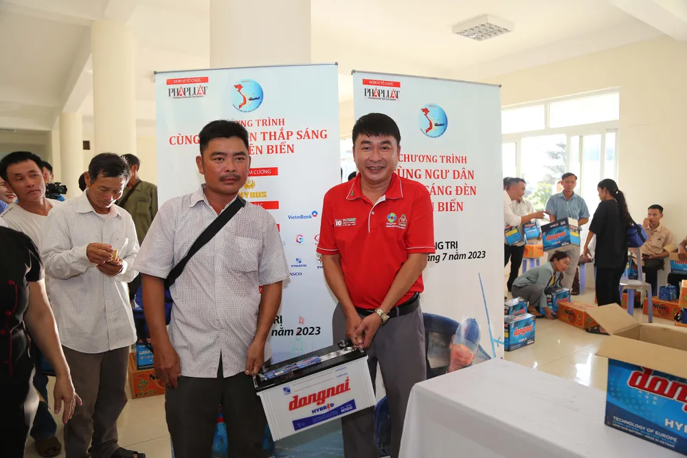 Ông Nguyễn Bá Sự, Giám đốc chi nhánh Công ty Dược TV.Pharm tại Đà Nẵng (áo đỏ), đại diện tặng quà ngư dân Quảng Trị. Ảnh: HOÀNG GIANG