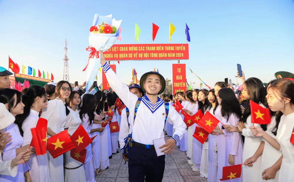 Chiến sĩ mới tạm biệt quê hương, nô nức lên đường về đơn vị mới. Ảnh: NX hon-1-200-thanh-nien-ninh-thuan-no-nuc-len-duong-nhap-ngu-5.jpg