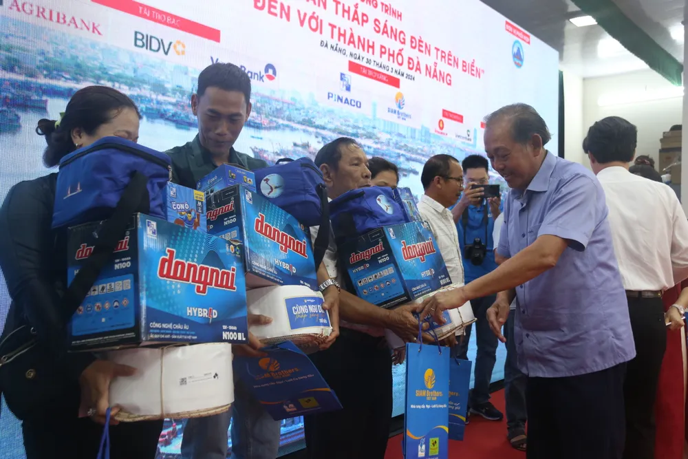 Ông Trương Hòa Bình, nguyên Ủy viên Bộ Chính trị, nguyên Phó Thủ tướng Thường trực Chính phủ, Chủ tịch danh dự của Chương trình, trao quà cho bà con ngư dân. chuong-trinh-cung-ngu-dan-thap-sang-den-tren-bien-tai-tp-da-nang-1.JPG