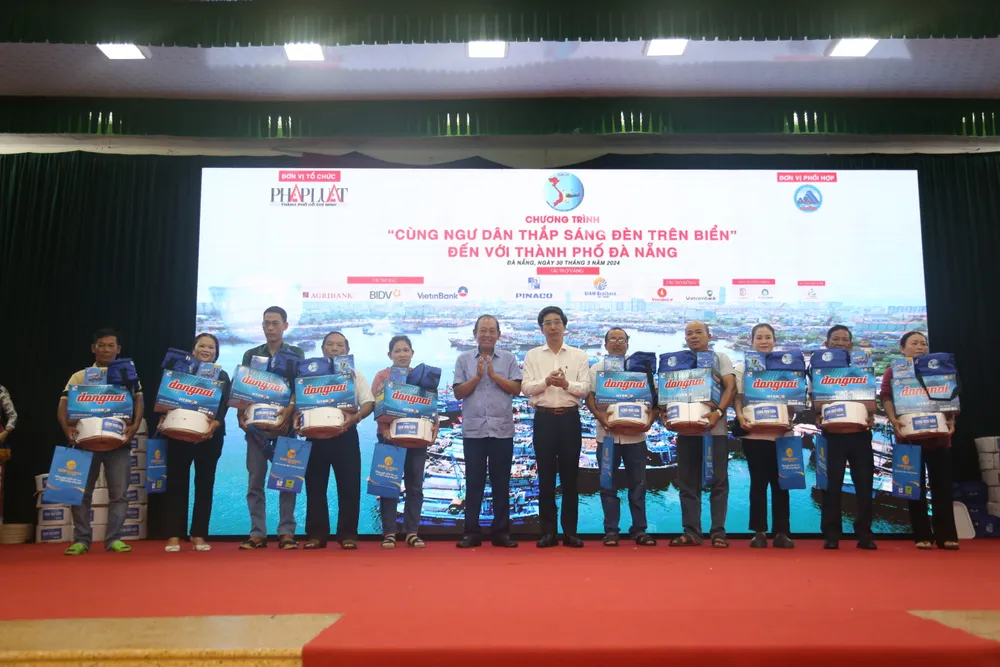 Nguyên Phó Thủ tướng Thường trực Chính phủ Trương Hòa Bình và Phó Chủ tịch UBND TP Đà Nẵng Trần Chí Cường trao quà tặng cho ngư dân. chuong-trinh-cung-ngu-dan-thap-sang-den-tren-bien-tai-tp-da-nang-2.JPG