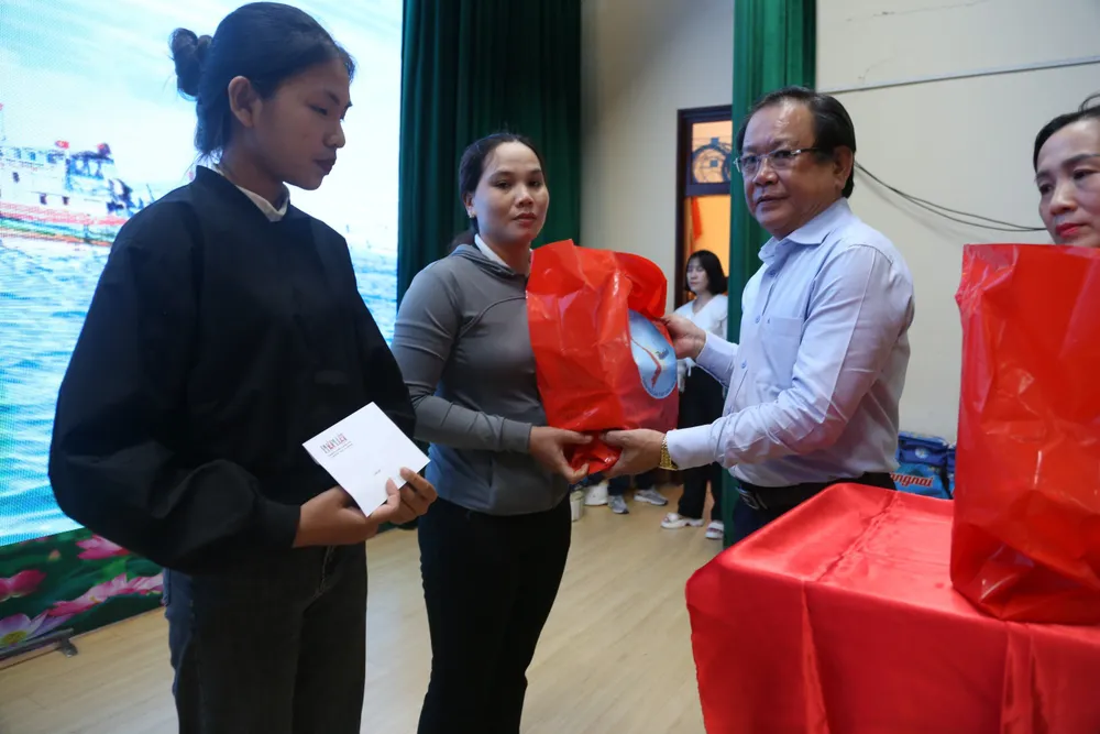 Ông Mai Ngọc Phước, Tổng Biên tập báo Pháp Luật TP.HCM, trao phần quà cho các đại diện gia đình ngư dân. dang-dien-ra-chuong-trinh-cung-ngu-dan-thap-sang-den-tren-bien-tai-quang-ngai-1.jpg
