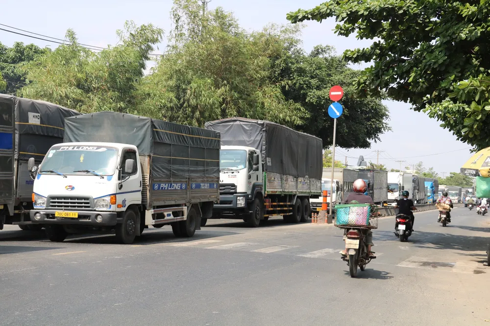 Hàng dài xe tải xếp hàng chờ lưu thông hướng từ tỉnh Long An đi TP.HCM. mo-rong-3.jpg