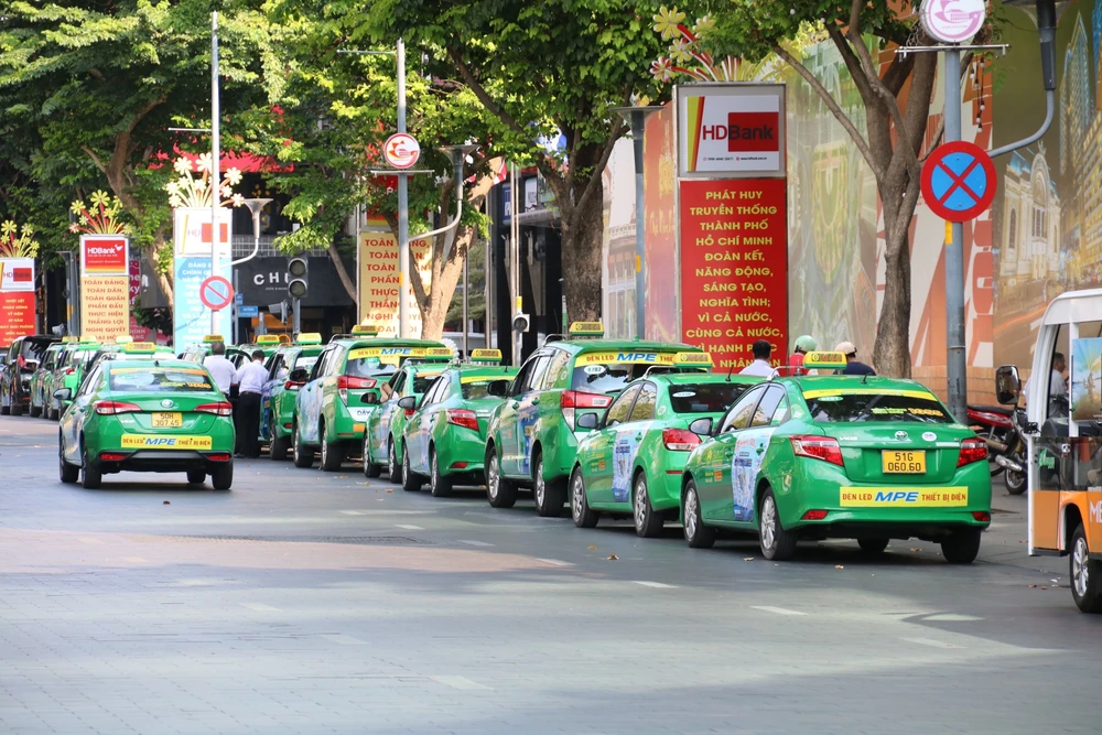 Xe dừng, đỗ ngay dưới biển cấm dừng, đỗ trên đường Nguyễn Huệ (quận 1). xe-taxi-3.jpg