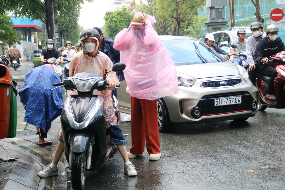 Người dân tấp vào lề đường mặc áo mưa trên đường Võ Thị Sáu, quận 3. mua-32.jpg