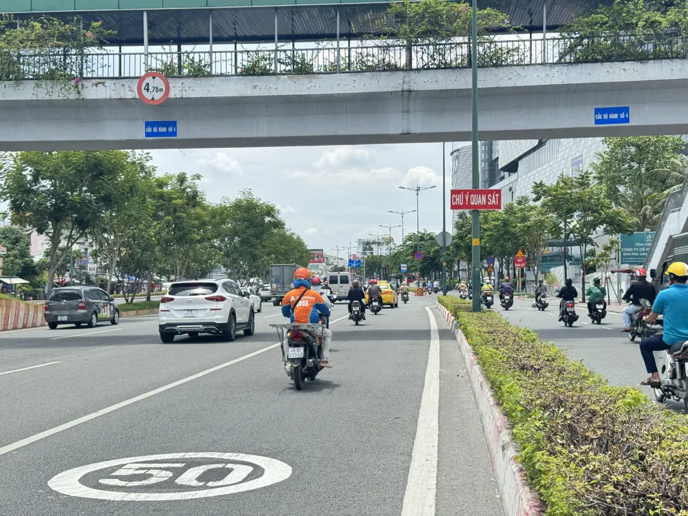 Biển báo giới hạn tốc độ ngay dưới mặt đường Phạm Văn Đồng. đường Phạm Văn Đồng