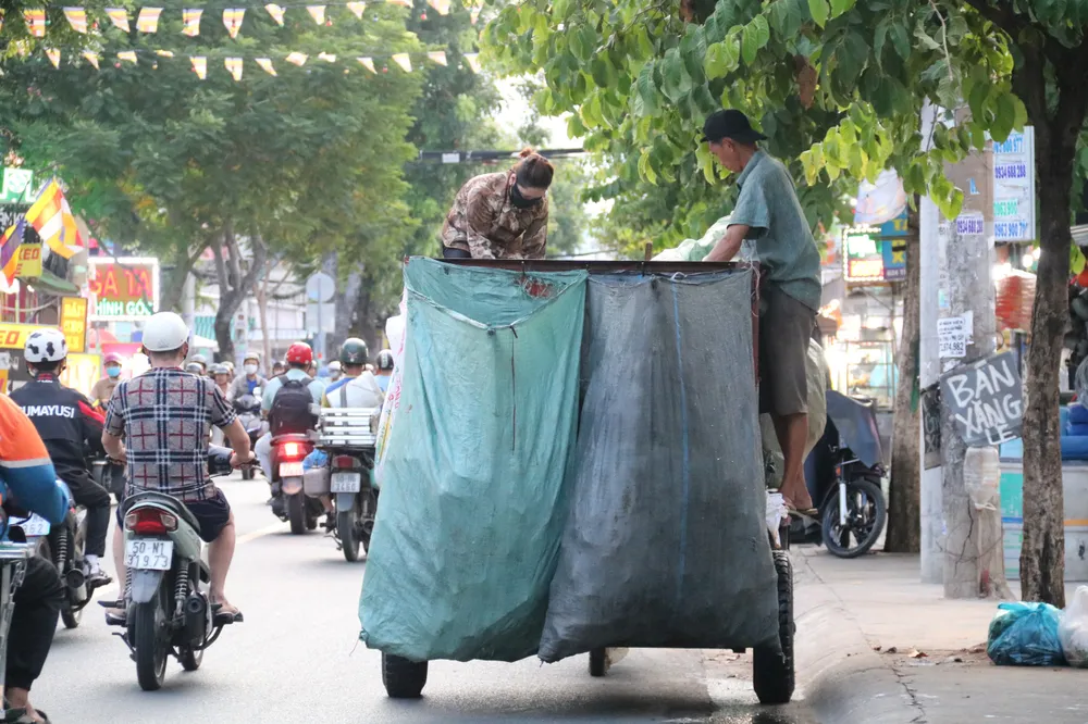 Người gom rác đứng trên thùng cao để phân loại, tiềm ẩn nhiều nguy hiểm. xe-rac-tho-so-6.jpg