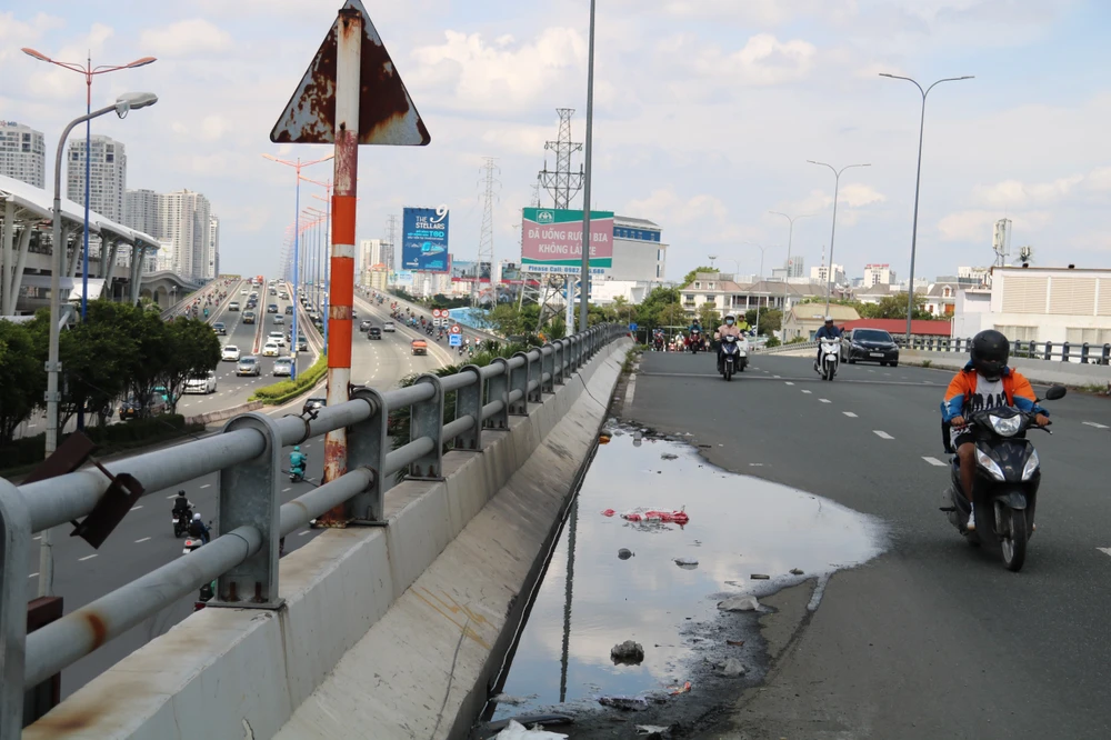 Mặt cầu xuất hiện vị trí lõm, tồn đọng nước. cầu vượt nguyễn hữu cảnh