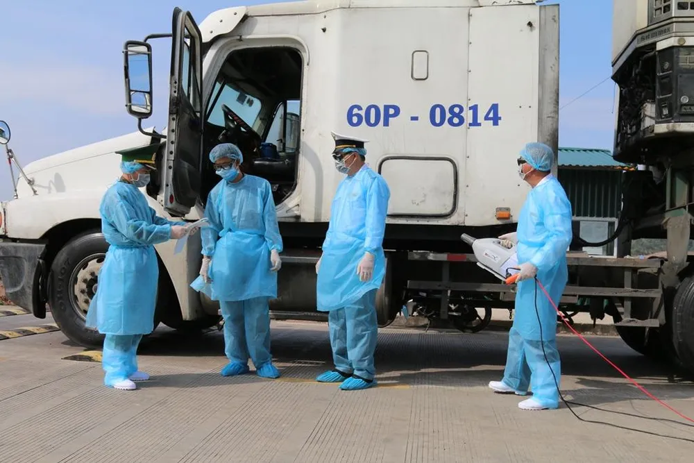 Lực lượng chức năng làm thủ tục và phun thuốc khử khuẩn cho phương tiện, hành hóa xuất nhập khẩu trên địa bàn thành phố Móng Cái. Ảnh: LÊ ĐỒNG