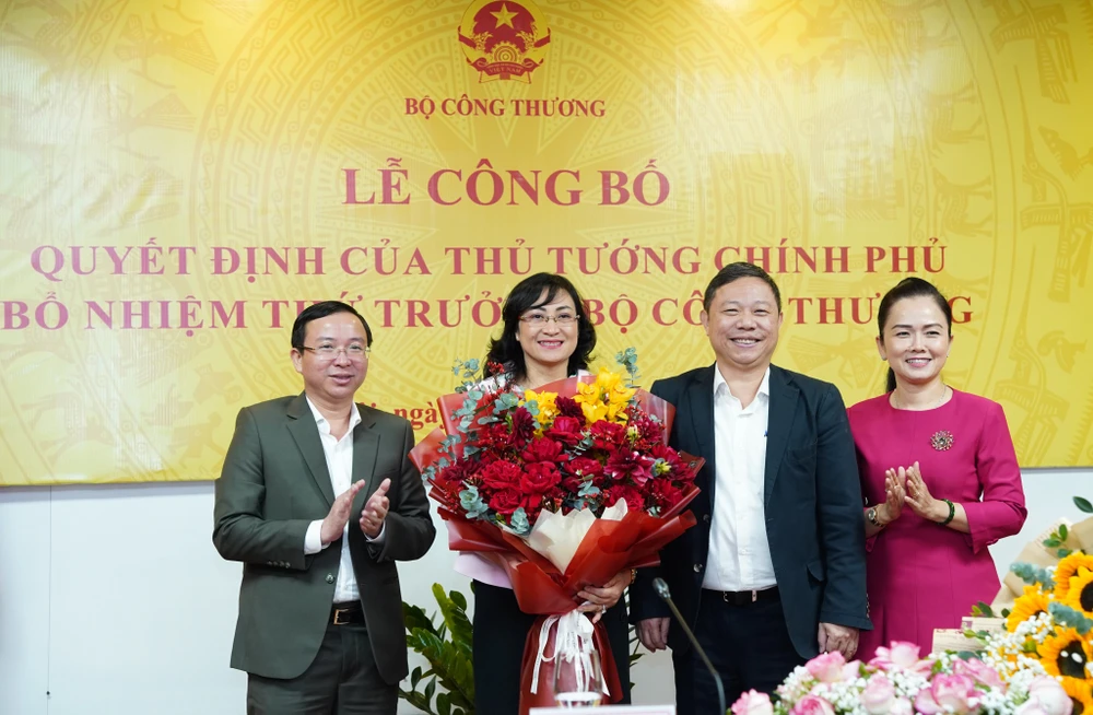 Phó Chủ tịch UBND TP.HCM Dương Anh Đức (bên phải) tặng hoa chúc mừng tân Thứ trưởng Phan Thị Thắng. Ảnh: CẤN DŨNG