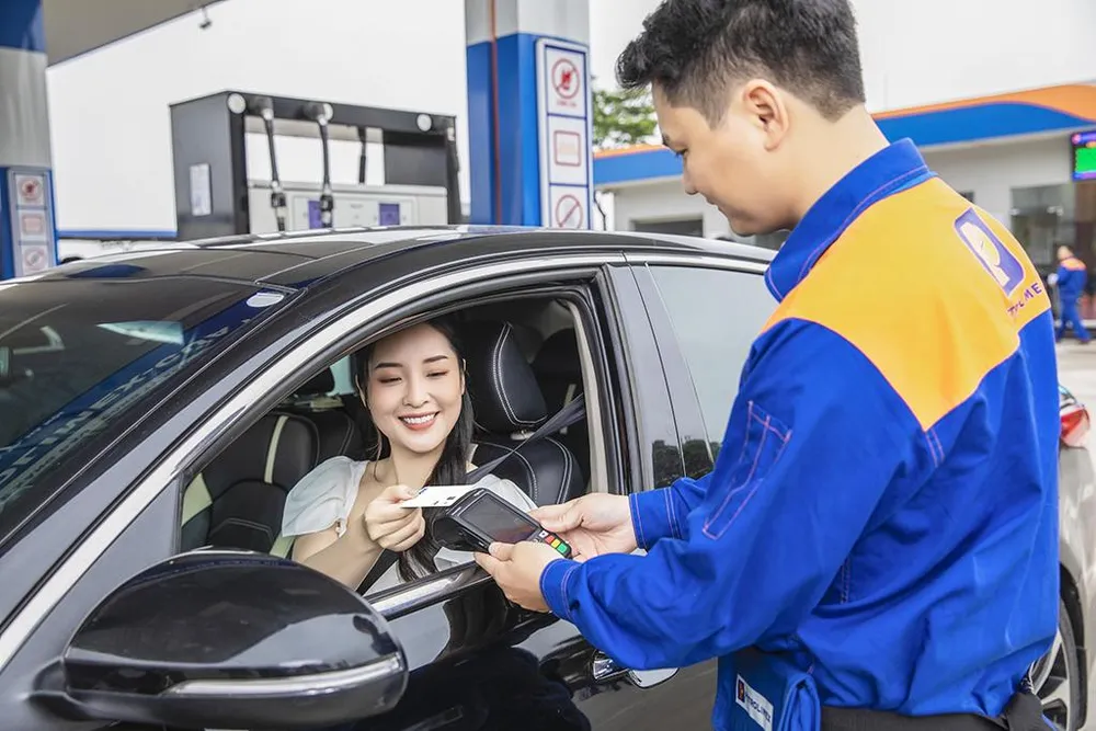 Khách hàng mua xăng dầu và thanh toán bằng thẻ không tiếp xúc Visa tại cửa hàng xăng dầu Petrolimex