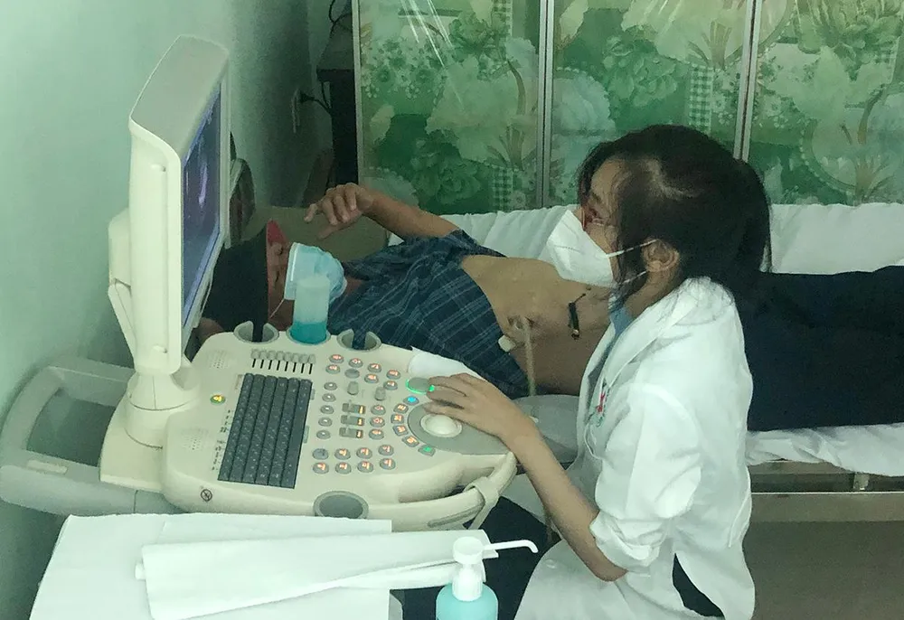 BS đang siêu âm bụng cho người lao động.