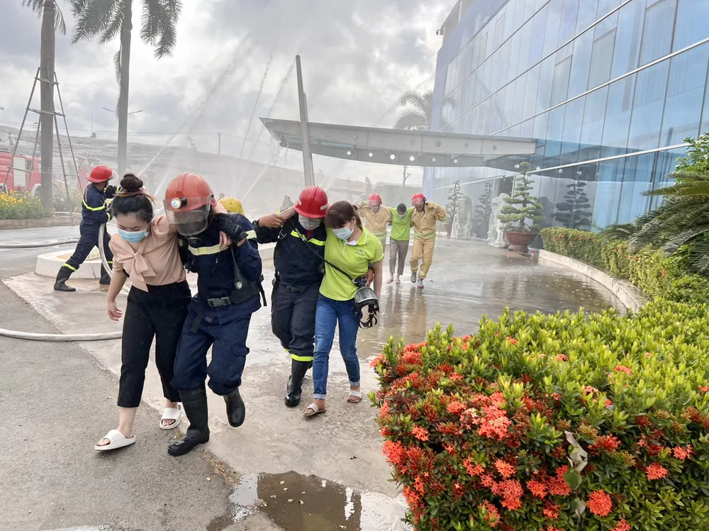 Lực lượng PCCC &amp; CNCH Công an huyện Bình Chánh phối hợp với lực lượng PCCC tại chỗ nhanh chóng đưa nhân viên thoát nhanh khỏi vùng cháy giả định.