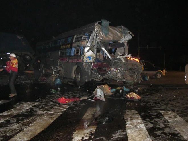 Cú đâm mạnh đã đẩy chiếc xe container lao vào lề đường, húc đổ cột điện cao áp và lật nghiêng. Chiếc xe khách đã bị biến dạng phần đầu, hư hỏng hoàn toàn.