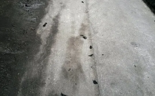 Mảnh vỡ mũ bào hiểm còn vương vãi trên nền ngõ