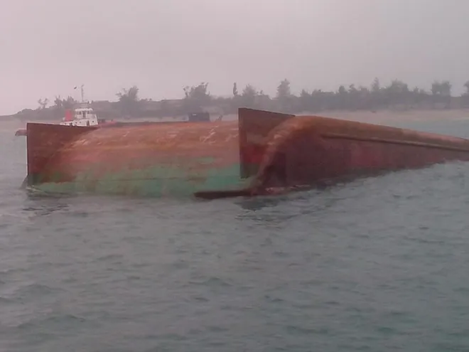 Hình ảnh chiếc sà lan bị lật trên biển.