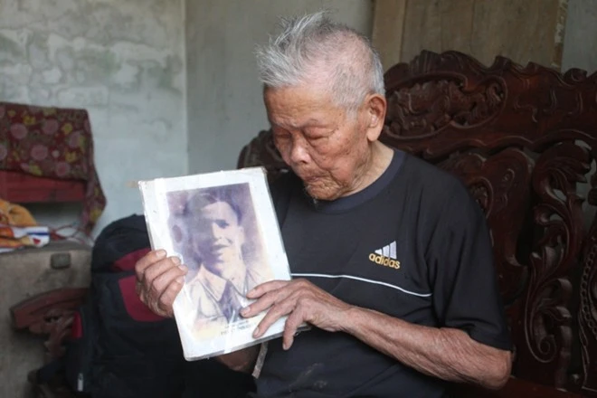 Cụ Giát cầm trên tay tấm hình duy nhất của người anh trai. Cụ Giát cầm trên tay tấm hình duy nhất của người anh trai.